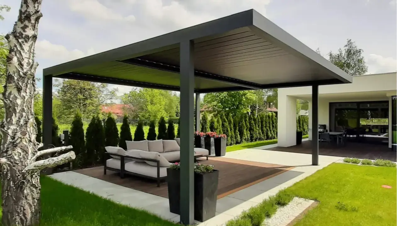 Nowoczesna pergola z wygodną sofą i stolikiem to idealne miejsce do wypoczynku. Zastanawiasz się, co położyć na taras? Tutaj widzisz gotową aranżację.