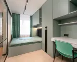 Nowoczesna aranżacja małej sypialni z funkcjonalną szafą wnękową, łóżkiem i biurkiem.