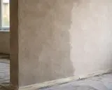 Ściana z nałożonym tynkiem, widać różnicę w wilgotności. Czekamy aż tynki schną.