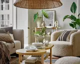 Przytulny salon w stylu skandynawskim z miękką sofą, puszystym fotelem i drewnianym stolikiem kawowym.