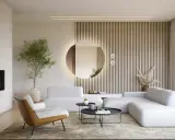 Okrągłe lustro w salonie, podświetlone od tyłu, odbija wnętrze. Obok niego pionowe lamele i nowoczesna sofa.