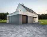Nowoczesne projekty kostki brukowej wokół domu tworzą elegancką nawierzchnię podjazdu i tarasu, podkreślając architekturę.