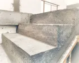 Surowe, betonowe stopnie schodowe w trakcie budowy. Solidna konstrukcja czeka na wykończenie.