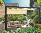Nowoczesna pergola z wysuwanym daszkiem to świetny sposób, jak osłonić taras od wiatru i słońca. Wygodny narożnik i stolik zachęcają do relaksu.