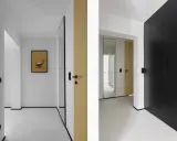 Minimalistyczny, mały przedpokój inspiracje ściany: złote i czarne drzwi, lustro, grafika z fotelem Eamesa.