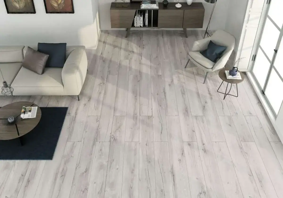 Nowoczesny salon z jasną sofą i fotelem. Podłoga z drewna, układanie płytek z przesunięciem 1/3, tworzy przytulną atmosferę.