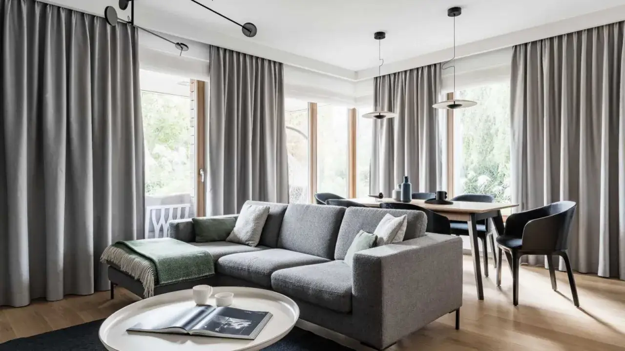 Nowoczesny wystrój okien galeria: szara sofa, stół z krzesłami i zasłony tworzą przytulną przestrzeń.