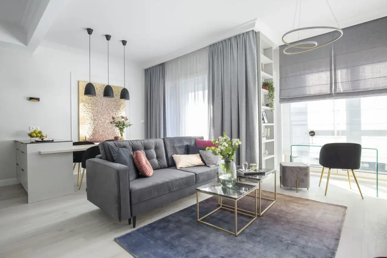 Nowoczesny wystrój okien galeria: szara sofa, stoliki kawowe, dywan, zasłony i rolety tworzą przytulną przestrzeń.