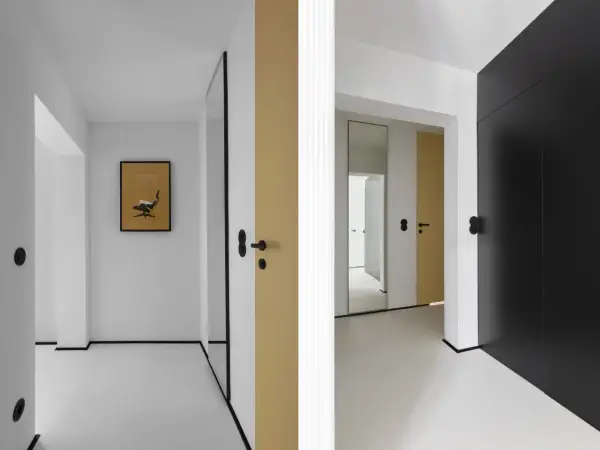 Minimalistyczny, mały przedpokój inspiracje ściany: złote i czarne drzwi, lustro, grafika z fotelem Eamesa.
